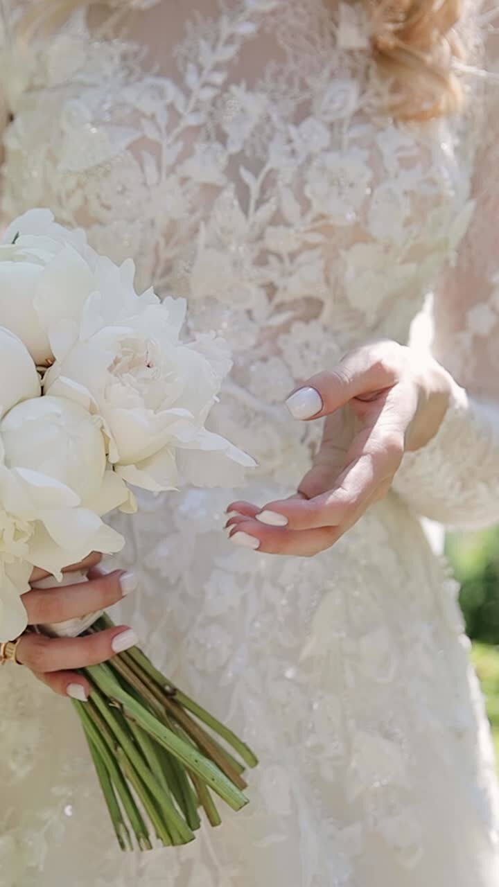 A bride holds wedding flowers bouquet in garden