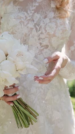 a bride holds wedding flowers bouquet in garden