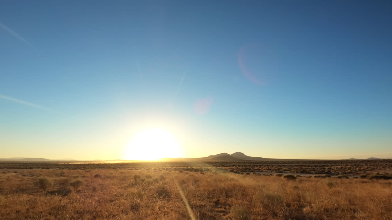 Time-lapse alba "Holy Grail" da notte a giorno del paesaggio del deserto del Mojave con un gregge di pecore che solleva polvere all'orizzonte