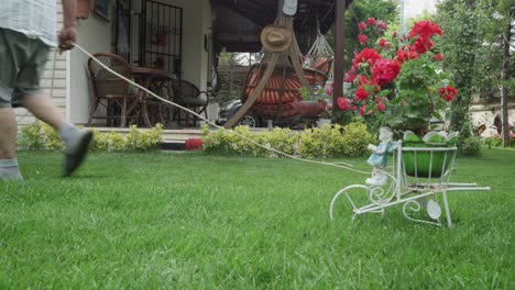 An-old-man-mowing-the-grasses-in-his-lawn-with-a-electrical-lawn-mower