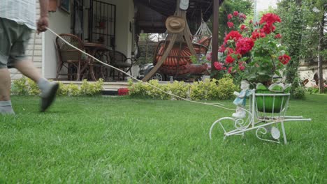 an old man mowing the grasses in his lawn with a electrical lawn mower