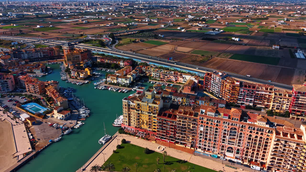 Aerial panorama of Port Saplaya marina and fields. Aerial panorama of Port Saplaya marina, colorful buildings, highway and farmland near Valencia, Spain
