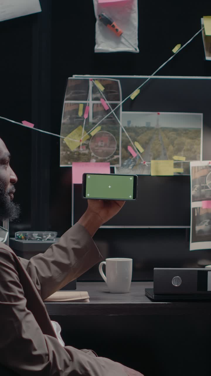Vertical video: Law agents team analyzing phone with green screen