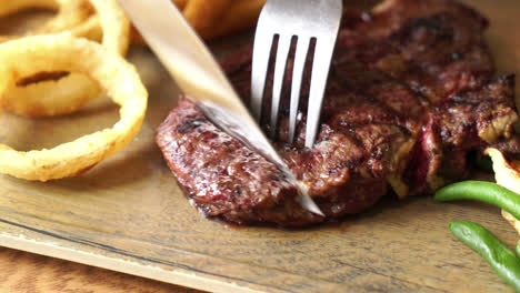 slicing beef steak on wood board