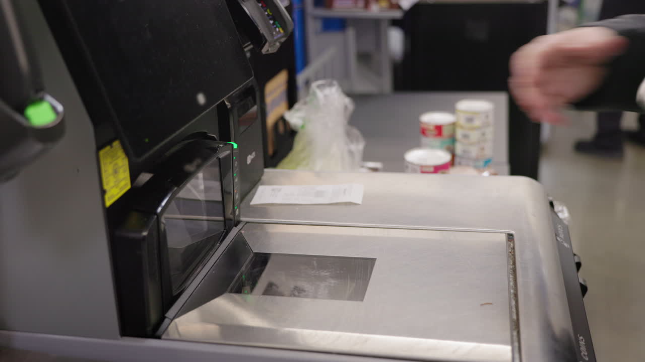 Person Scanning Canned Goods at Self-Checkout in Supermarket