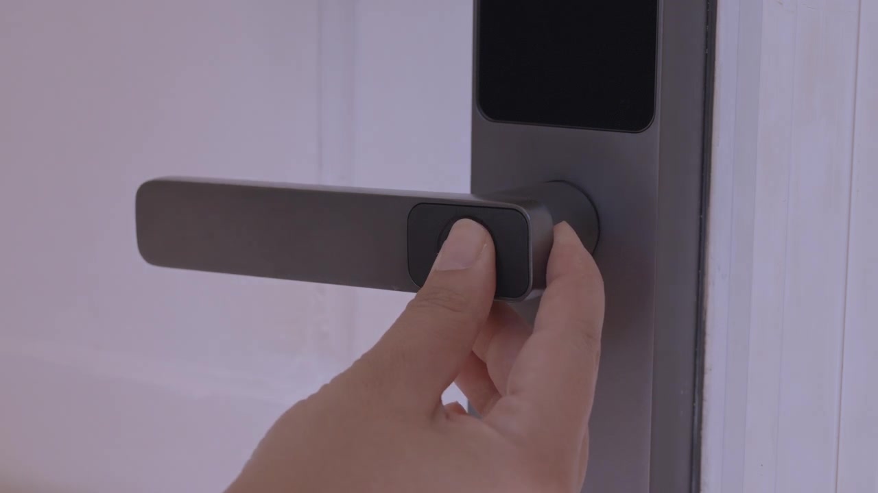 A video showing a hand unlocking a smart door handle with a fingerprint scanner and walking inside.