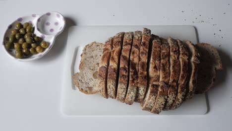 sliced olive bread with green olives on the side, perfect for a cozy meal or snack