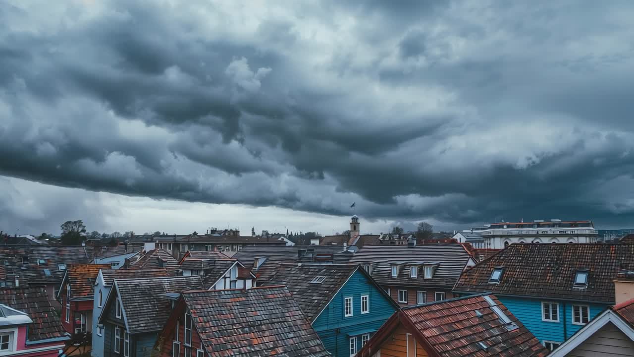 Avanzata di un fronte temporalesco con nube a mensola su tetti di una città e campanile di una chiesa, che segnala pioggia