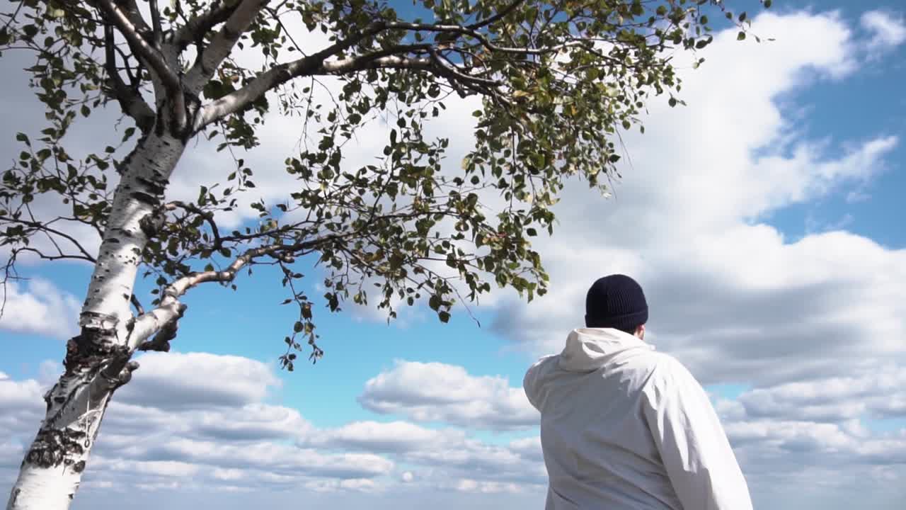 버드나무 에 의해 구름 이 가득 한 하늘 을 바라보는 사람