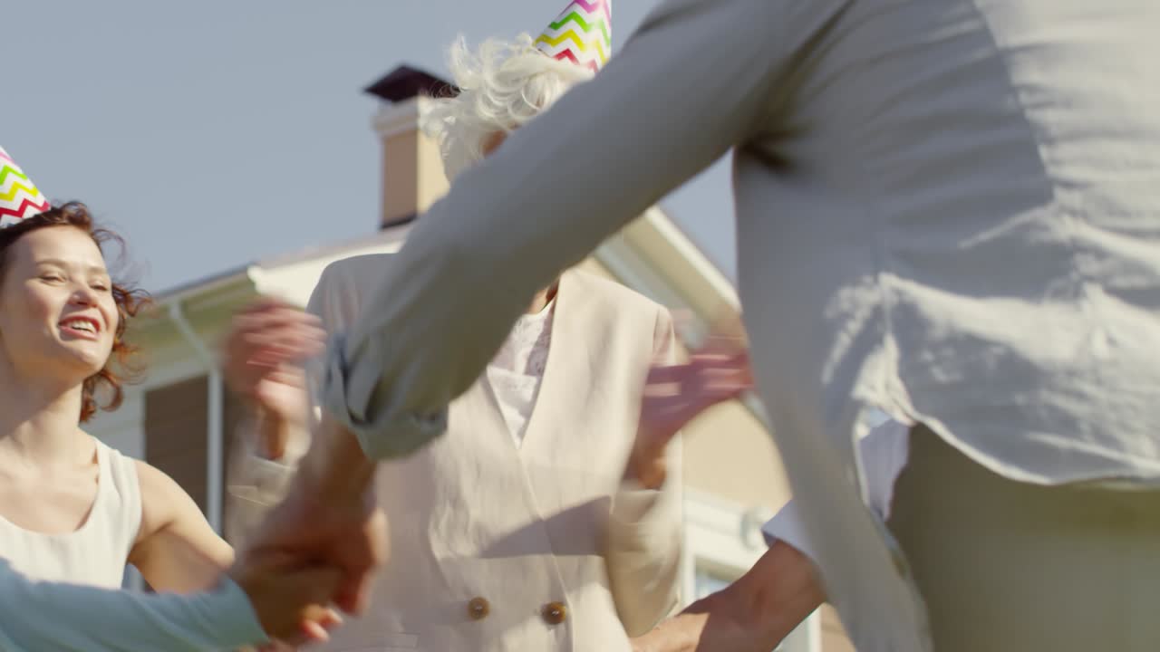 가족과 함께 야외에서 생일을 축하하는 고령 여성