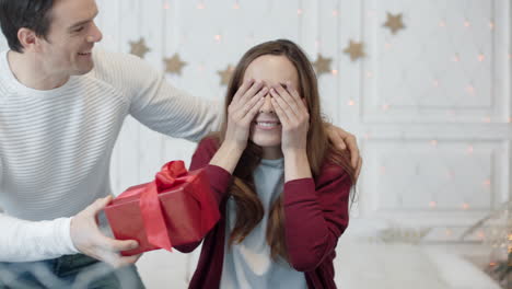 cheerful woman closing eyes with hands in luxury house. smiling couple hugging