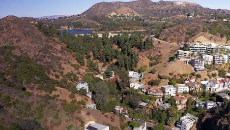 Toma-Aérea-Inversa-Sobre-Las-Colinas-De-Hollywood-Con-El-Lago-Hollywood-De-Fondo