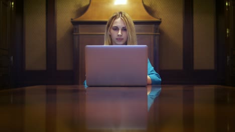 mujer de negocios trabajando en una computadora portátil sentada en un escritorio en casa
