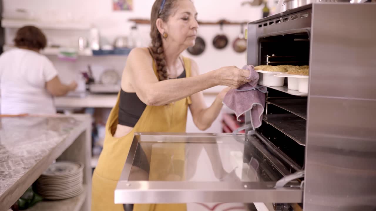 Mexican woman baking dessert in oven at home