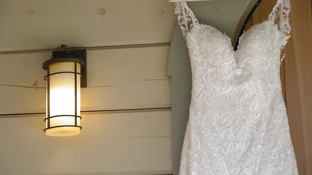 Elegant close up of a white wedding gown hanging on the exterior of a guesthouse at the Le Belvédère in Wakefield, Quebec, Canada