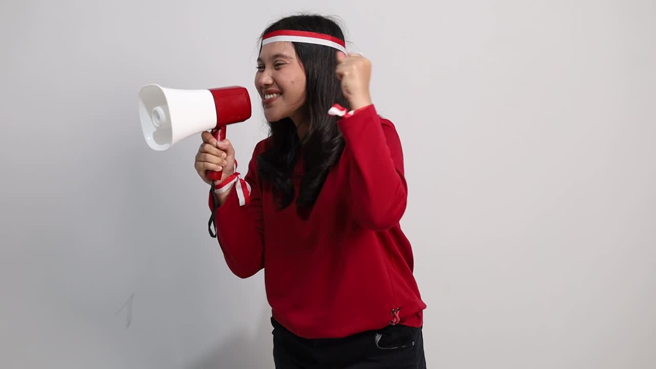 Young Female Fan support of Indonesian national team shout and scream on megaphone isolated on white background