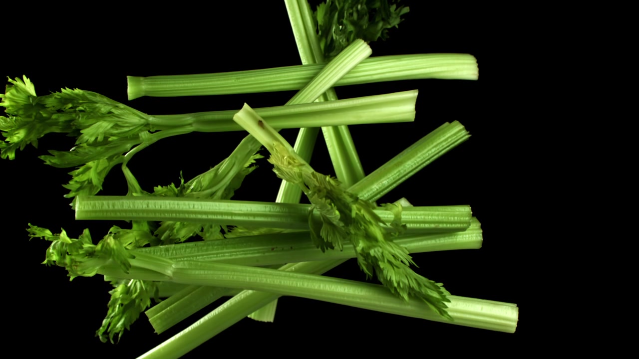 Gambi di sedano verde fresco che cadono e si accumulano