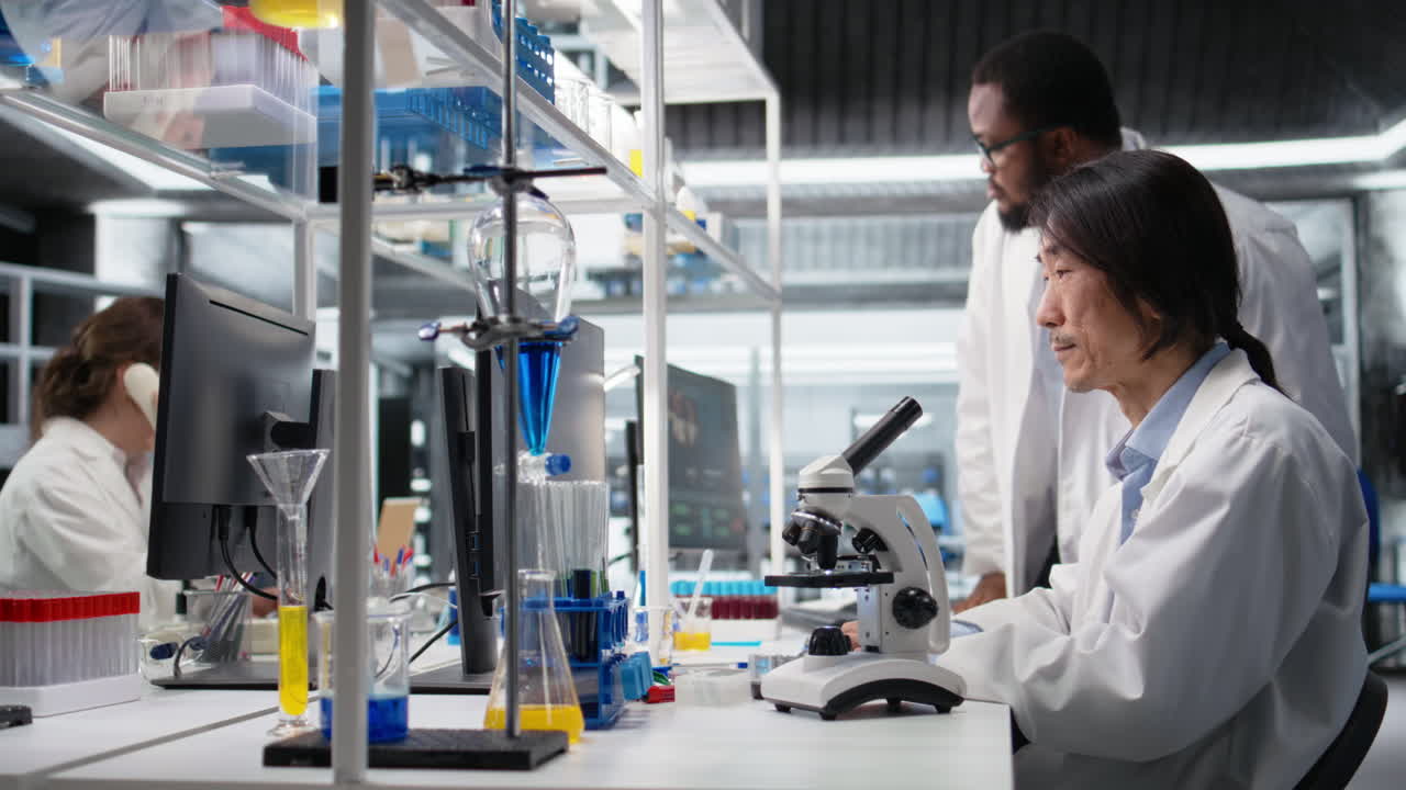 Vertical video Microscopist uses compound microscope to study genetic material