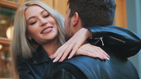 portrait of pretty young blonde woman in makeup hugging boyfriend