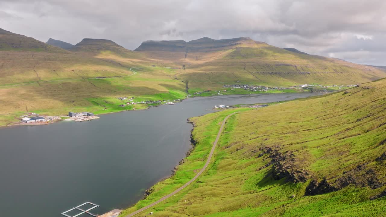 A scenic aerial view of the Faroe Islands' serene fjord surrounded by green hills