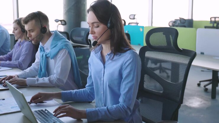 Professional Call Center Team Working on Laptops with Headsets