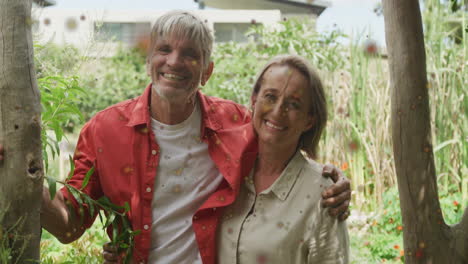 animation of red spots over happy caucasian couple embracing in garden