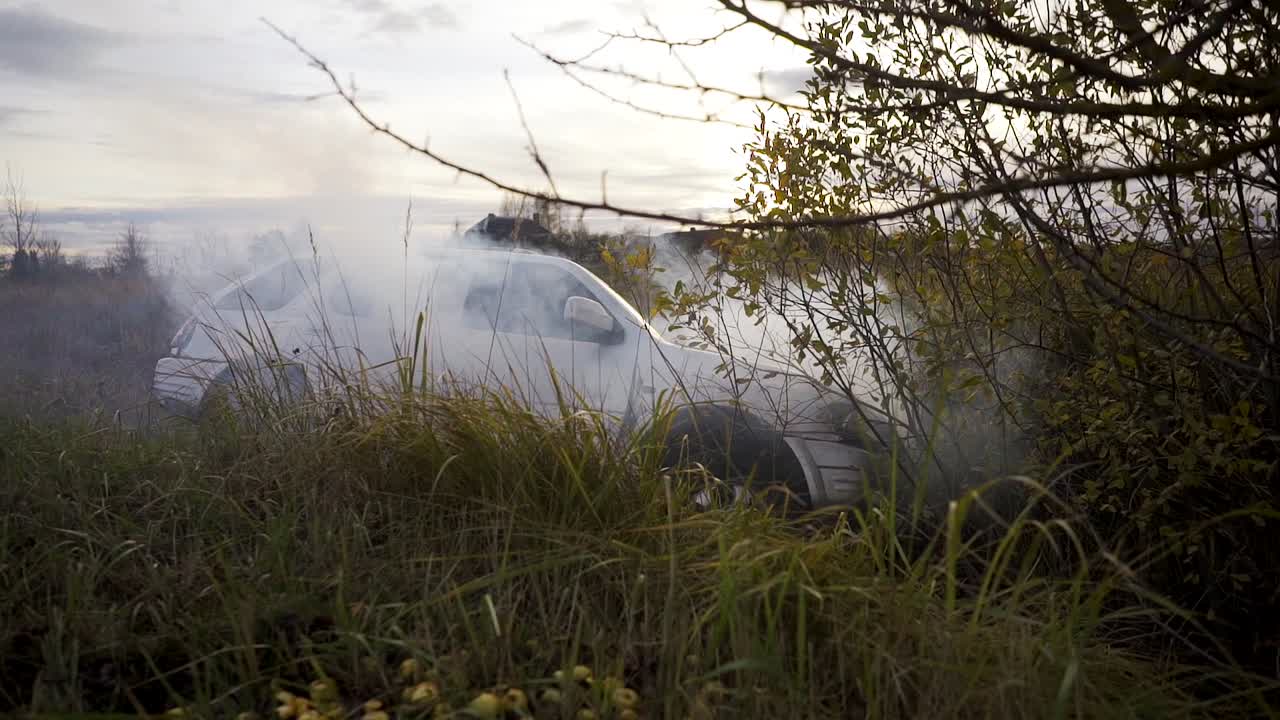 A vehicle with mechanical problems is on the side of the road in an area with grass