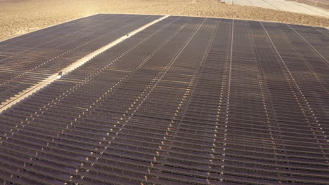 stunning aerial footage of a massive solar farm with thousands of solar panels stretching across the landscape