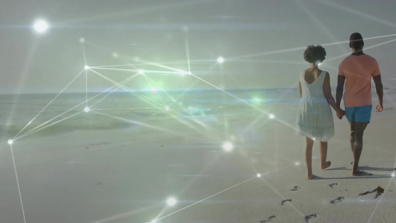 Couple starting frame strolling hand-in-hand along shore leaving footprints IT overlay revealing