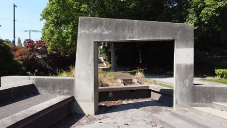 2-2 pan out from a mystical modern concrete gateway to an empty quiet futuristic fountain unmanaged by the city park by day and by night ritualistic gatherings occur with druids witches magical beings