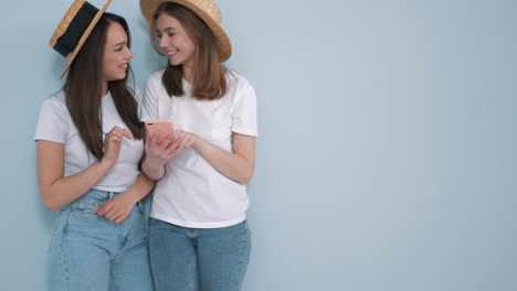 dos amigas mirando un teléfono