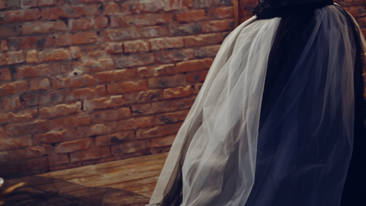 Witch at table. Portrait of woman dressed in witch style sitting by the table