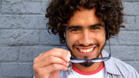 Young-man-removing-his-spectacles