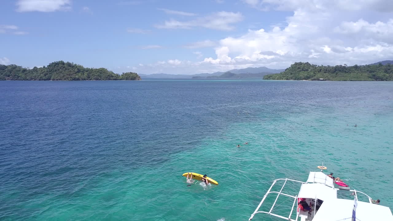 People Enjoying a Water Slide Boat in Tropical Turquoise Waters Among Islands