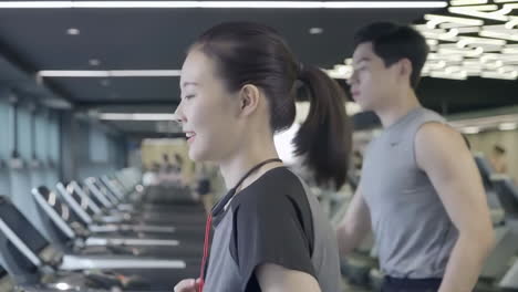 sports fit girls woman running on a treadmill exercise machine before gym workout at health club