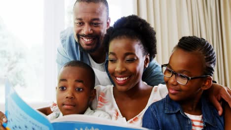 Parents-and-kids-sitting-together-on-sofa-with-photo-album