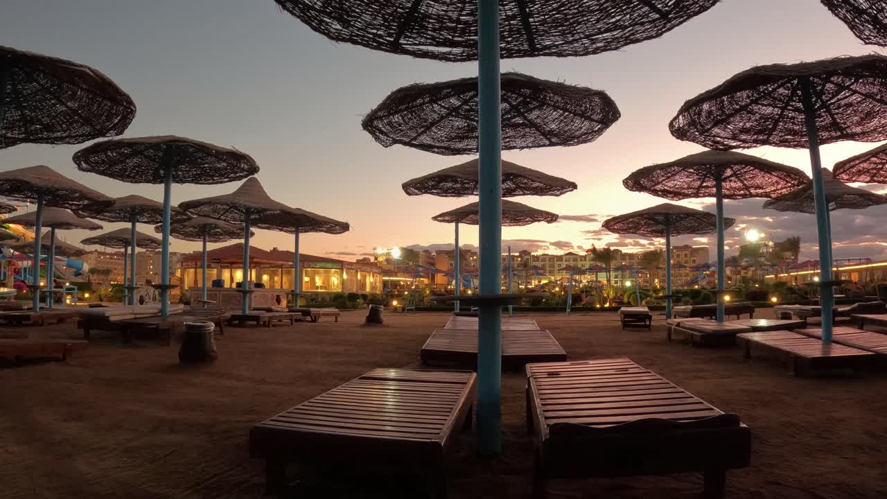 lapso de tiempo de la puesta de sol en la playa con sombrillas y sillas de playa con piscina de fondo de playa de mar con una vista increíble de la puesta de sol