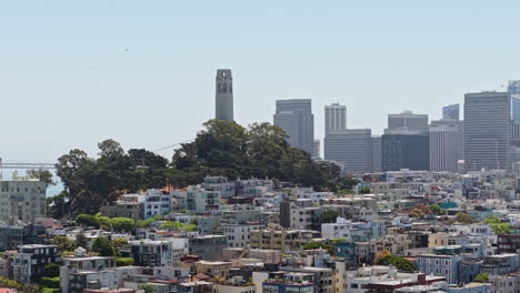 san francisco usa, drone shot of coit tower landmark on telegraph hill with downtown skyscrapers in misty background