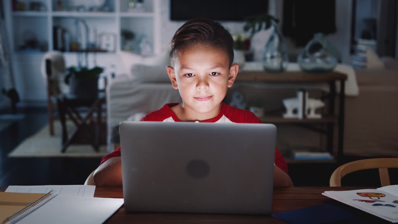 niño hispano pre-adolescente sentado en la mesa de comedor haciendo su tarea usando una computadora portátil, de cerca