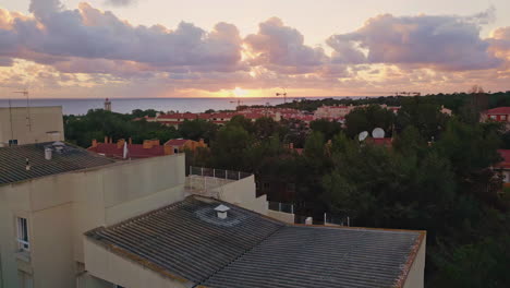 coastal town lit evening sunset light. drone view sea horizon over tiled roof