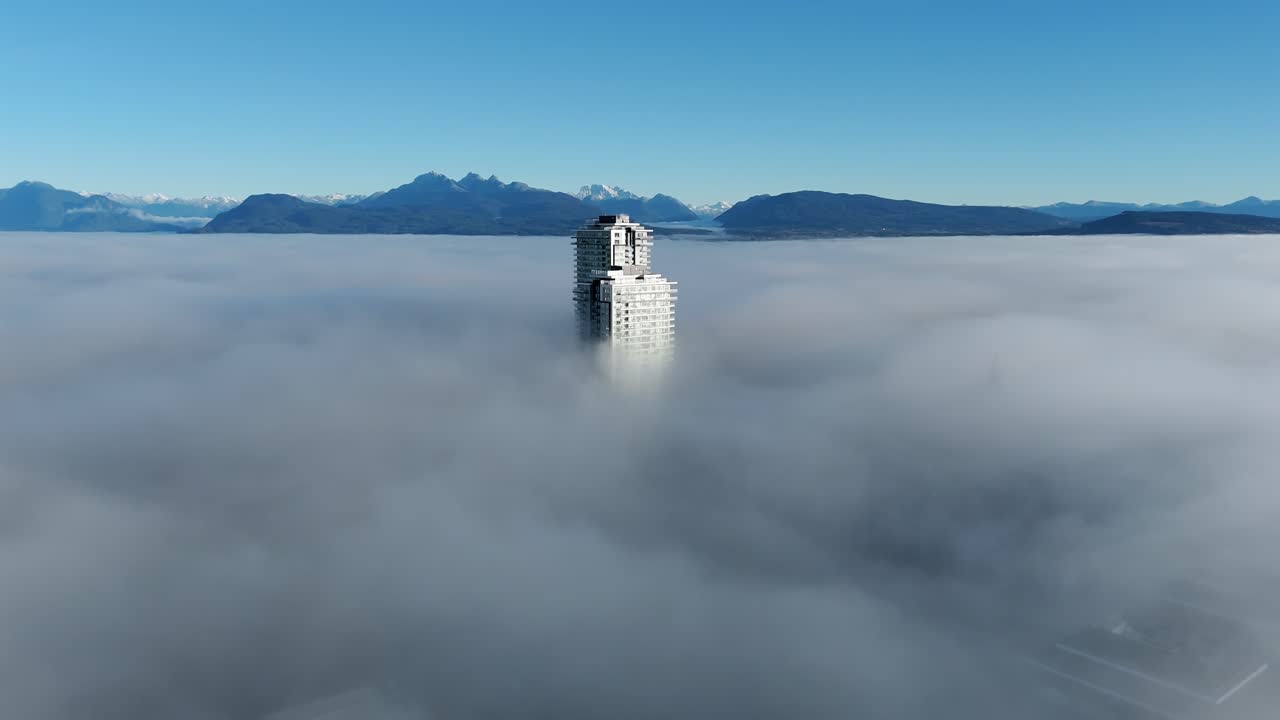Grattacielo solitario attraverso una fitta coltre di nebbia a Langley, Metro Vancouver, Canada. Ampia ripresa con drone.