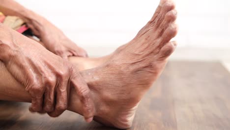 persona de edad avanzada estirando y masajeando los pies
