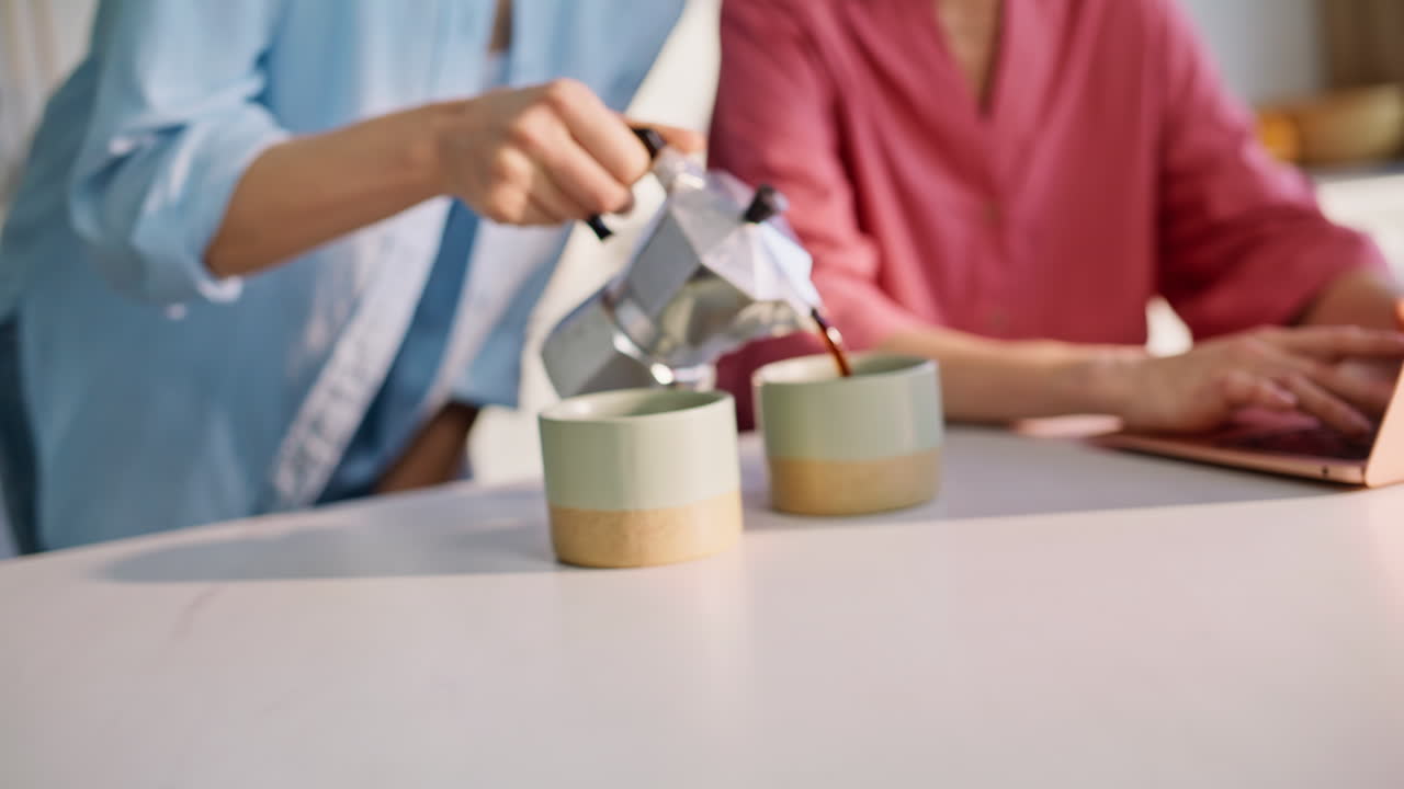 Primo piano di una donna che offre un caffè alla moglie nella cucina di casa. Una bruna triste condivide i suoi problemi