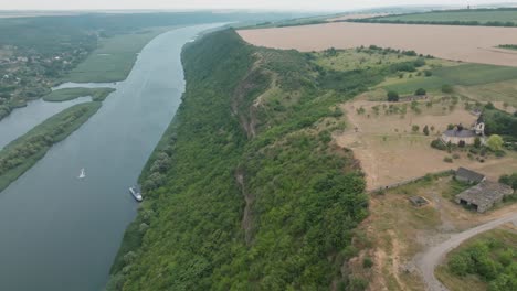 movement of the drone camera from the top of the hill from where the church is visible towards the river