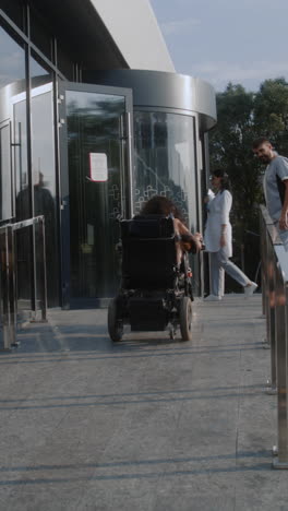 person in wheelchair at hospital entrance