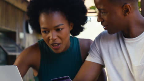 Close-Up-Of-Excited-Couple-With-Credit-Card-Using-Laptop-At-Home-To-Book-Holiday-Or-Shop-Online