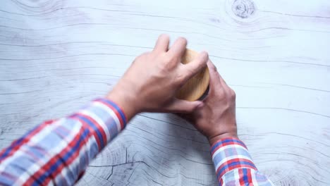 mano alcanzando galletas en un cuenco de vidrio en una mesa de madera