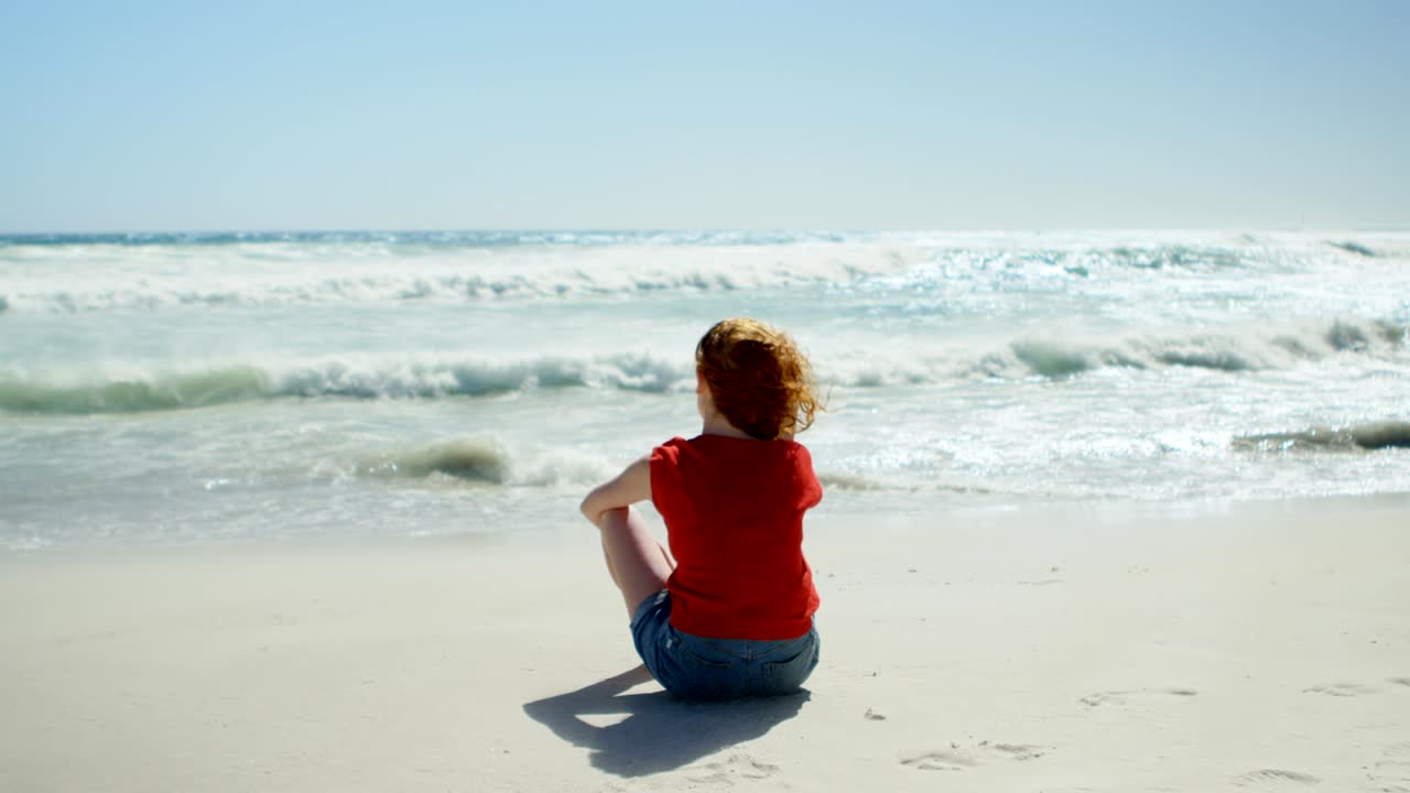 모래 위에 앉아서 바다를 바라보는 여자 4k