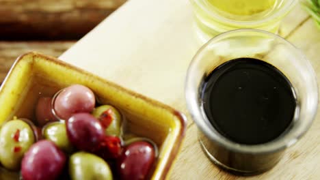 Rosmarin,-Olivenöl-Und-Marinierte-Oliven-Auf-Holzbrett