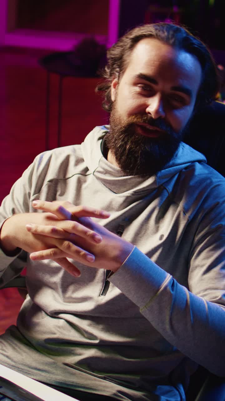 Video verticale. Gamer professionista in studio che spiega agli spettatori le strategie per battere gli avversari durante il livestream